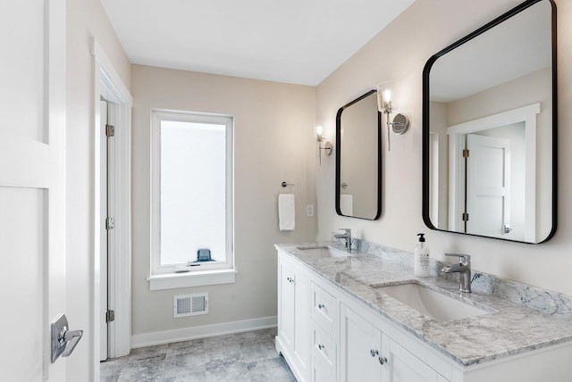 full bath with double vanity, baseboards, visible vents, and a sink