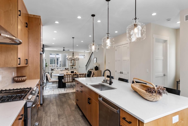 kitchen featuring dark wood-style floors, recessed lighting, a large island with sink, a sink, and appliances with stainless steel finishes