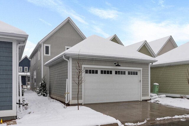 view of snowy exterior featuring an attached garage