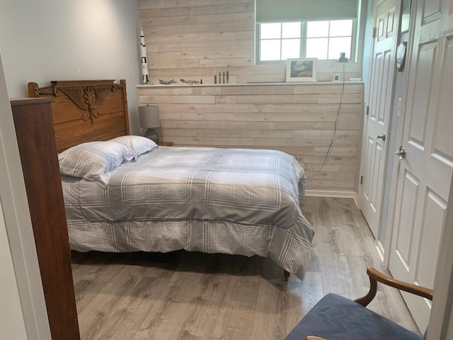 bedroom with wood walls and hardwood / wood-style flooring