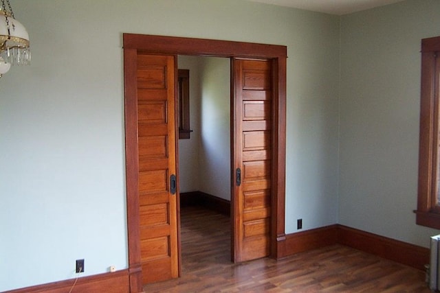 empty room with dark hardwood / wood-style flooring