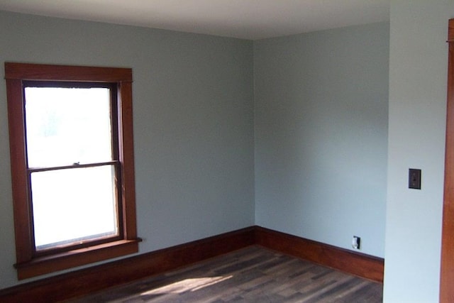 empty room featuring dark hardwood / wood-style flooring and a healthy amount of sunlight