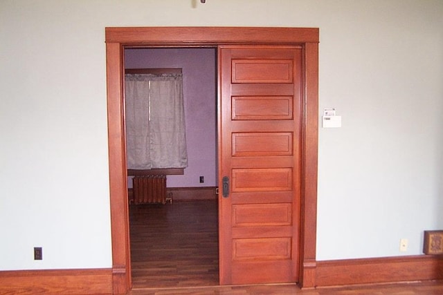 hall featuring radiator heating unit and wood-type flooring