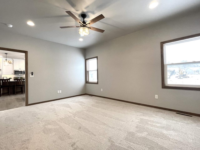 empty room featuring ceiling fan and carpet floors