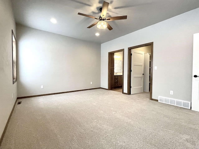 unfurnished bedroom with ceiling fan, light carpet, and ensuite bath