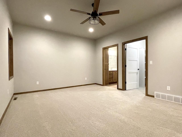 unfurnished bedroom with ceiling fan, light colored carpet, and ensuite bathroom