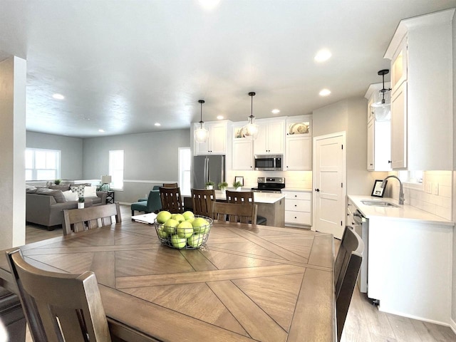 dining space featuring sink and light hardwood / wood-style flooring