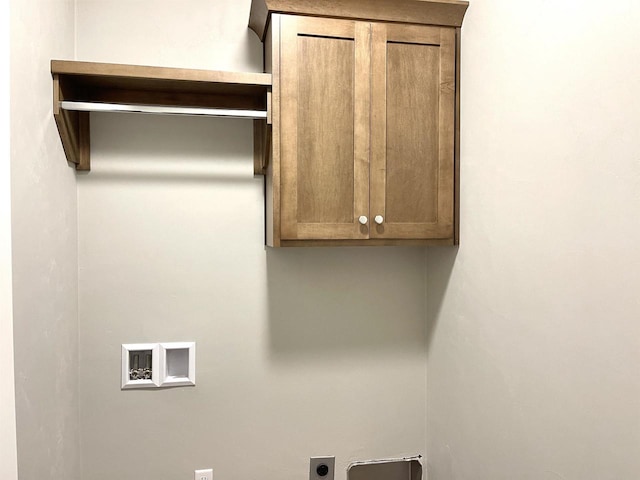 laundry area featuring electric dryer hookup, hookup for a washing machine, and cabinets