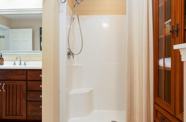 bathroom with a stall shower, visible vents, and vanity