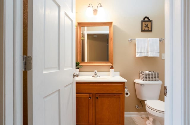 bathroom featuring toilet, tile patterned flooring, baseboards, and vanity