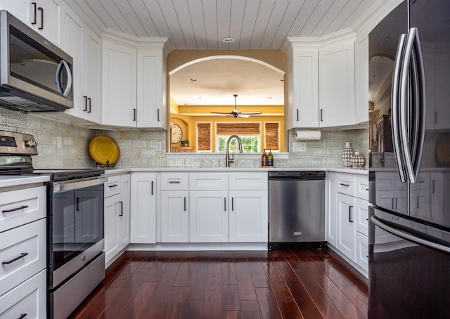 kitchen featuring dark hardwood / wood-style flooring, white cabinetry, backsplash, and stainless steel appliances