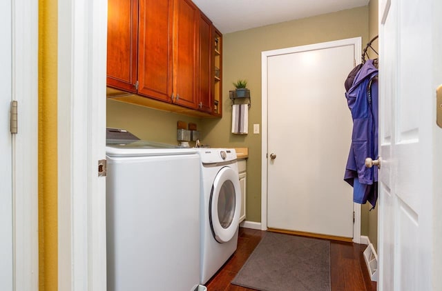 washroom featuring cabinet space, visible vents, baseboards, dark wood-style flooring, and independent washer and dryer