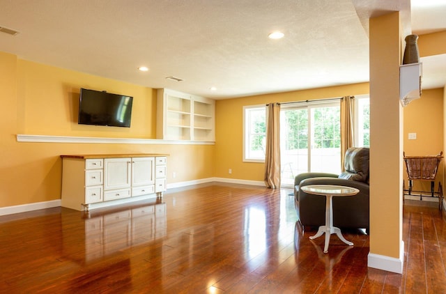 living area with dark wood-style floors, baseboards, and recessed lighting