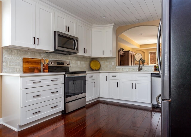 kitchen featuring dark hardwood / wood-style flooring, white cabinets, and appliances with stainless steel finishes