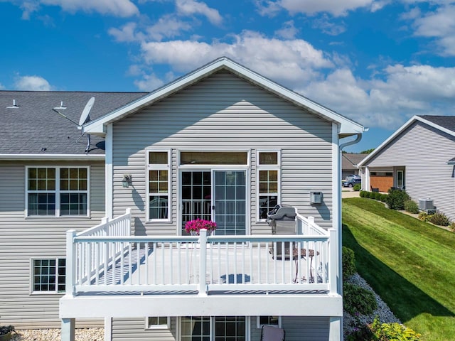 back of property featuring a lawn and central AC unit