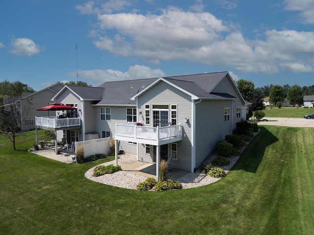 back of house with a patio area, a lawn, and a wooden deck