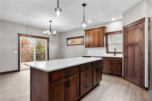 kitchen with light wood-type flooring, light countertops, and a sink