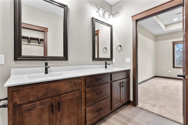 bathroom featuring double vanity, baseboards, and a sink