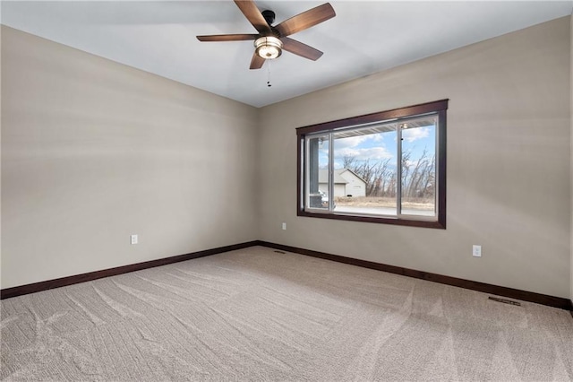 empty room with carpet floors, visible vents, and baseboards