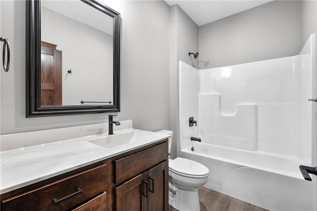 full bathroom featuring toilet, bathing tub / shower combination, wood finished floors, and vanity