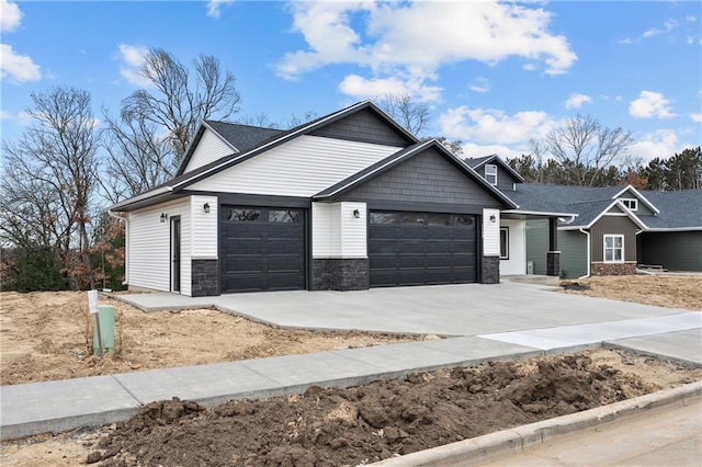 single story home featuring a garage, concrete driveway, and stone siding