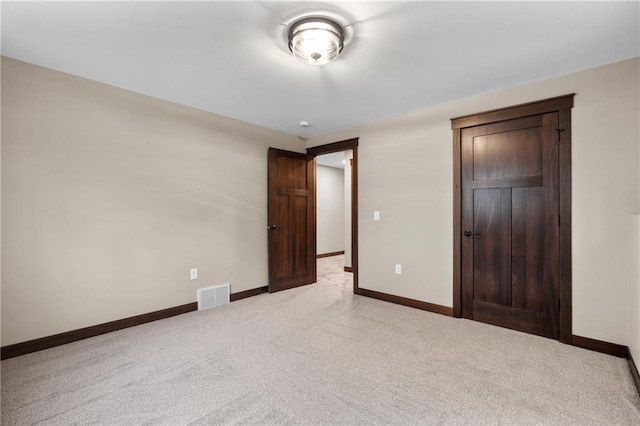 unfurnished bedroom with baseboards, visible vents, a closet, and light colored carpet