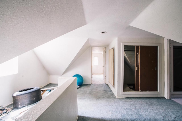 bonus room featuring a textured ceiling, carpet, and vaulted ceiling