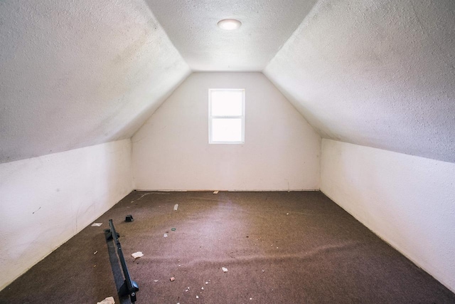 bonus room featuring carpet flooring, lofted ceiling, and a textured ceiling