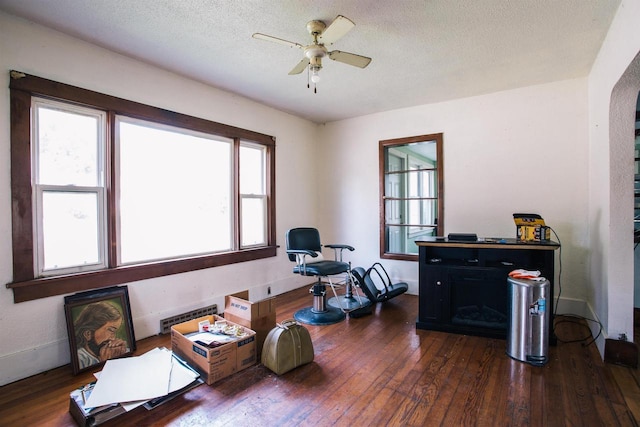 office area featuring ceiling fan, dark hardwood / wood-style flooring, a textured ceiling, and a healthy amount of sunlight