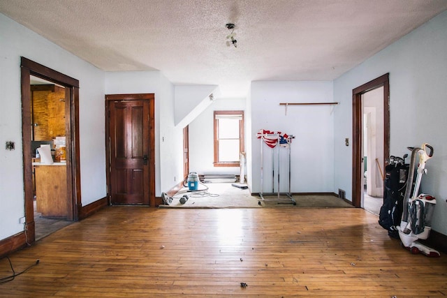 interior space featuring hardwood / wood-style flooring and a textured ceiling