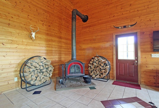 7750 Pine Rd, Arena, WI 53503 - entrance foyer featuring light tile patterned flooring, wood walls, and a wood stove