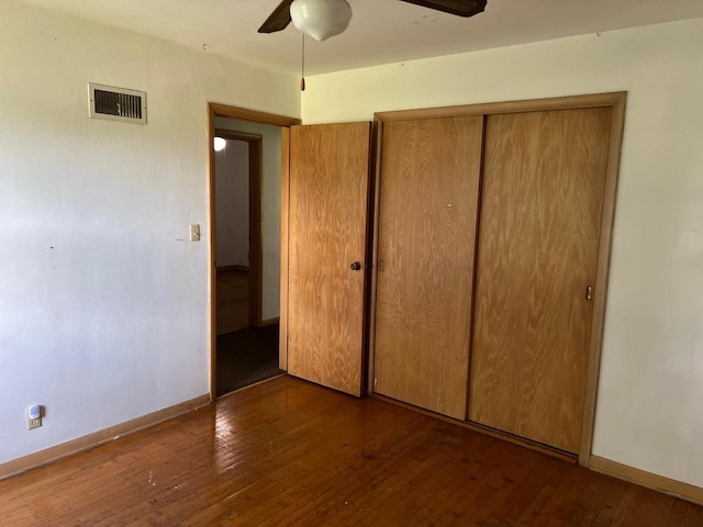 unfurnished bedroom featuring a closet, ceiling fan, and dark hardwood / wood-style floors