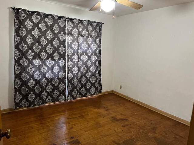 empty room featuring ceiling fan and dark hardwood / wood-style flooring