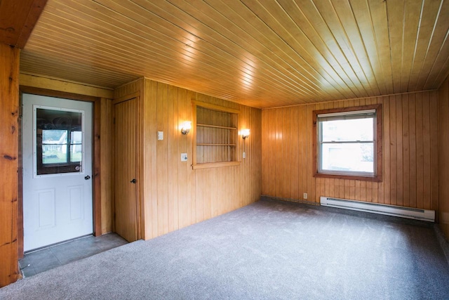 interior space featuring wood walls, wood ceiling, and a baseboard heating unit