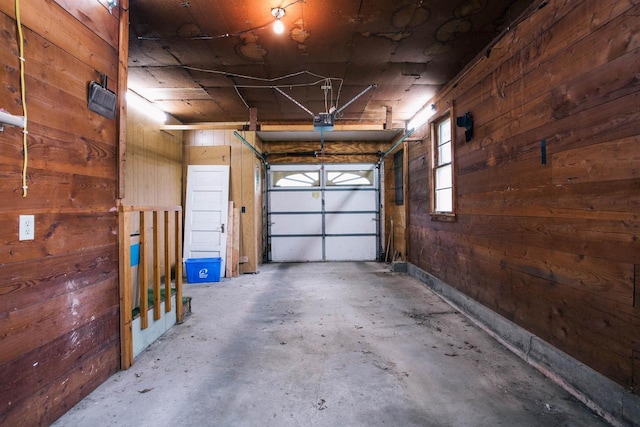 garage with a garage door opener and wooden walls