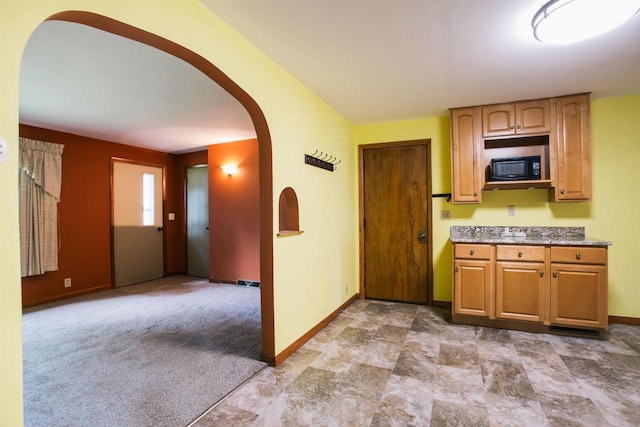 kitchen featuring black microwave and tile patterned flooring