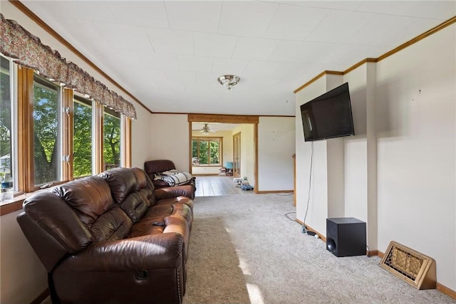 carpeted living area with crown molding and baseboards