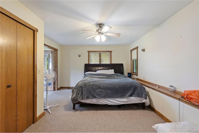 carpeted bedroom with a closet, ceiling fan, and baseboards