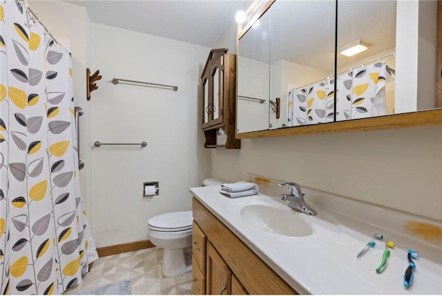 bathroom with a shower with shower curtain, toilet, vanity, baseboards, and tile patterned floors