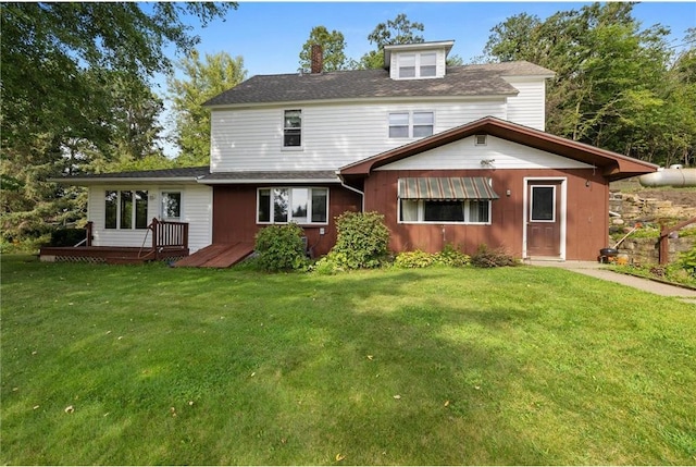 view of front of home with a front yard and a wooden deck