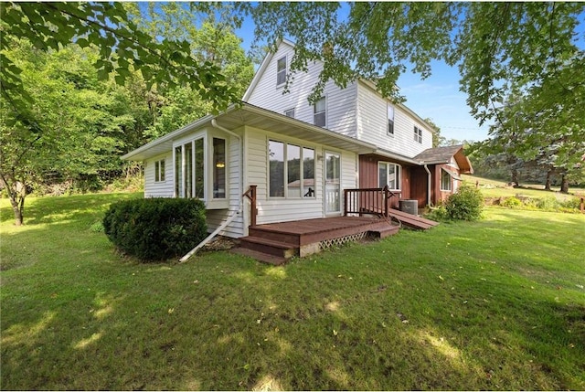 rear view of property featuring a lawn and a wooden deck