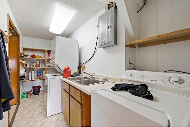 laundry area featuring a textured ceiling, a sink, cabinet space, light floors, and washer / clothes dryer