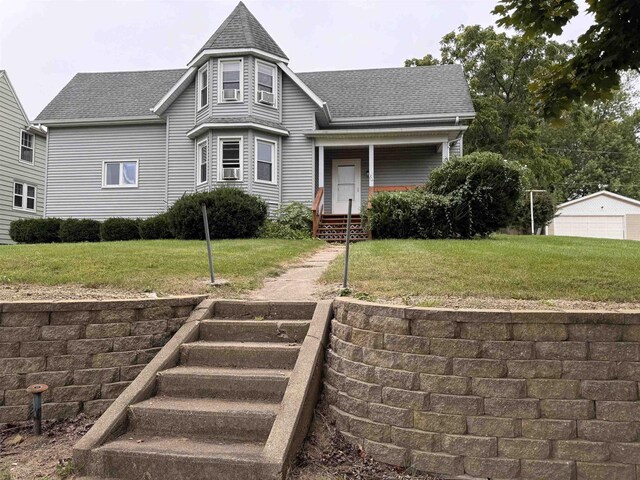 view of front of house with a garage, an outdoor structure, and a front yard