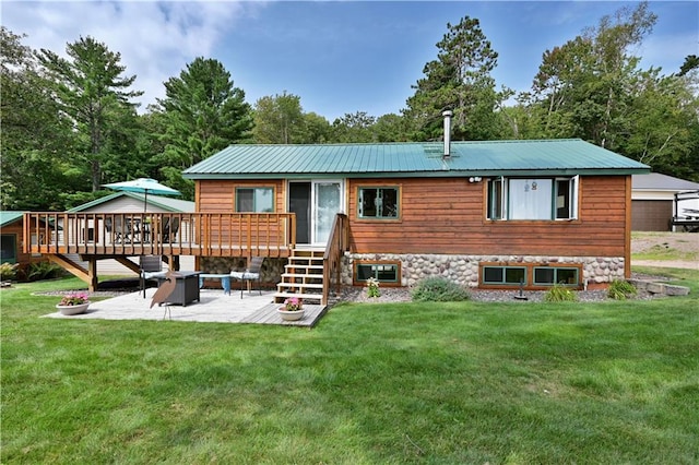 rear view of property with an outbuilding, a patio, a lawn, a garage, and a deck