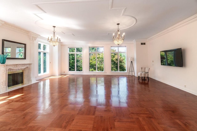 unfurnished living room with visible vents, baseboards, a premium fireplace, ornamental molding, and a chandelier