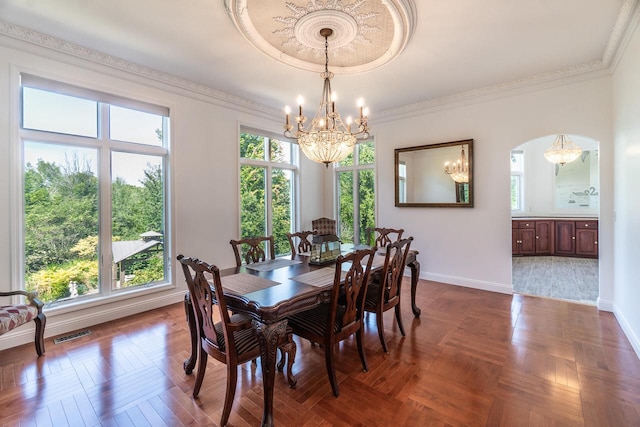 dining area with ornamental molding, a healthy amount of sunlight, visible vents, and baseboards