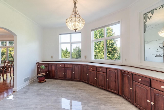 interior space featuring a chandelier, ornamental molding, visible vents, and baseboards