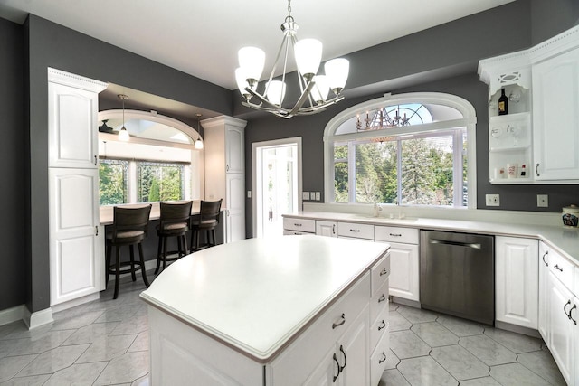 kitchen featuring white cabinets, dishwasher, a center island, light countertops, and open shelves