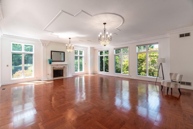 unfurnished living room featuring ornamental molding, visible vents, a notable chandelier, and a premium fireplace