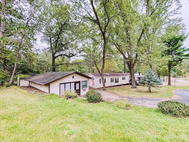 view of front of house with a garage, aphalt driveway, and a front yard